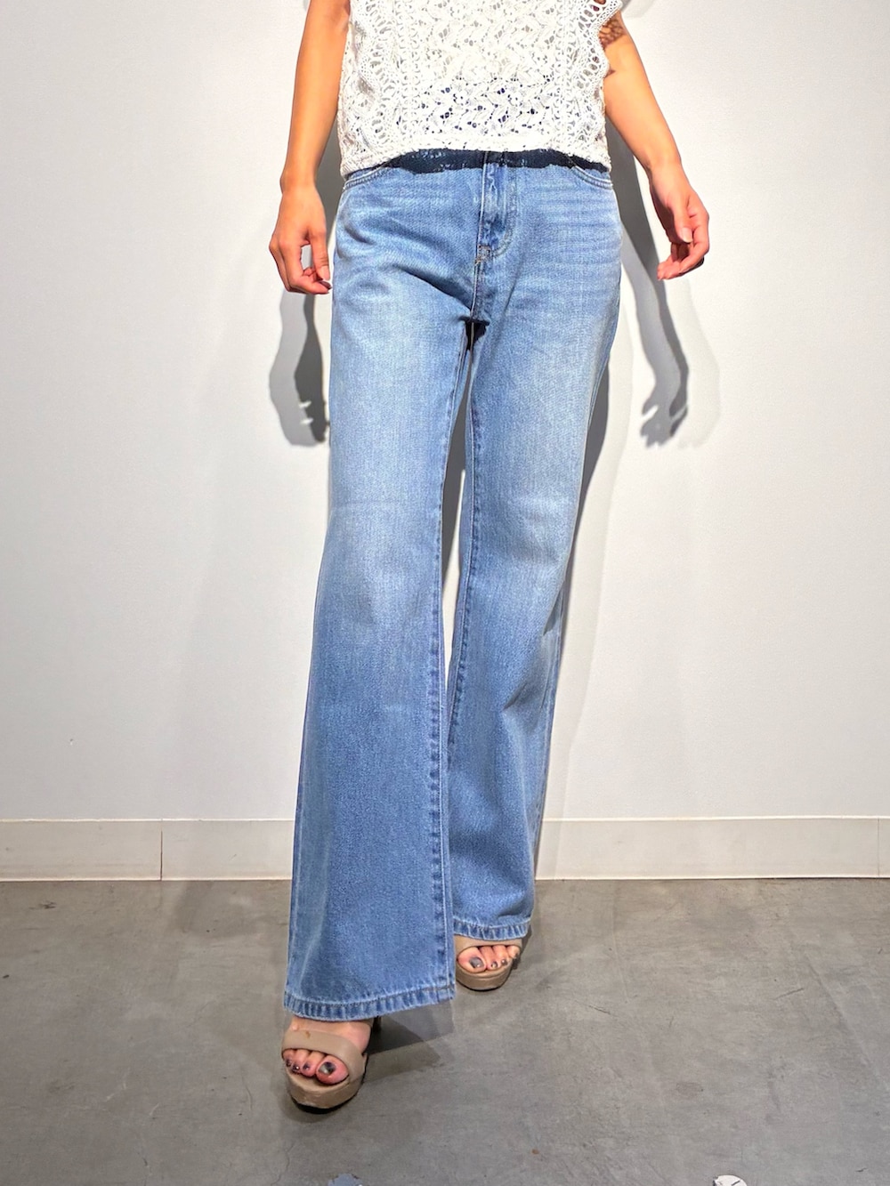 グレー系のデニムパンツ、ベージュ系のトートバッグ、ホワイト系のトップスを着用したレディースの夏コーディネートの8枚目の写真