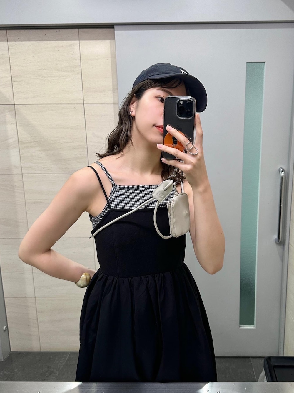 ブラック系のキャミソール、ブラック系のサンダル、ブラック系のワンピースを着用したレディースの春コーディネートの5枚目の写真