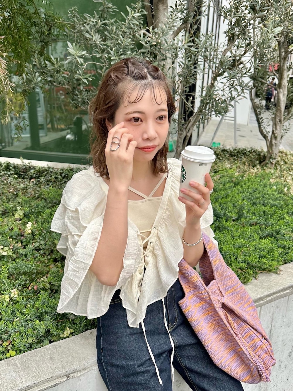 ブルー系のデニムパンツ、ホワイト系のシャツ/ブラウス、ホワイト系のキャミソールを着用したレディースの春コーディネートの2枚目の写真