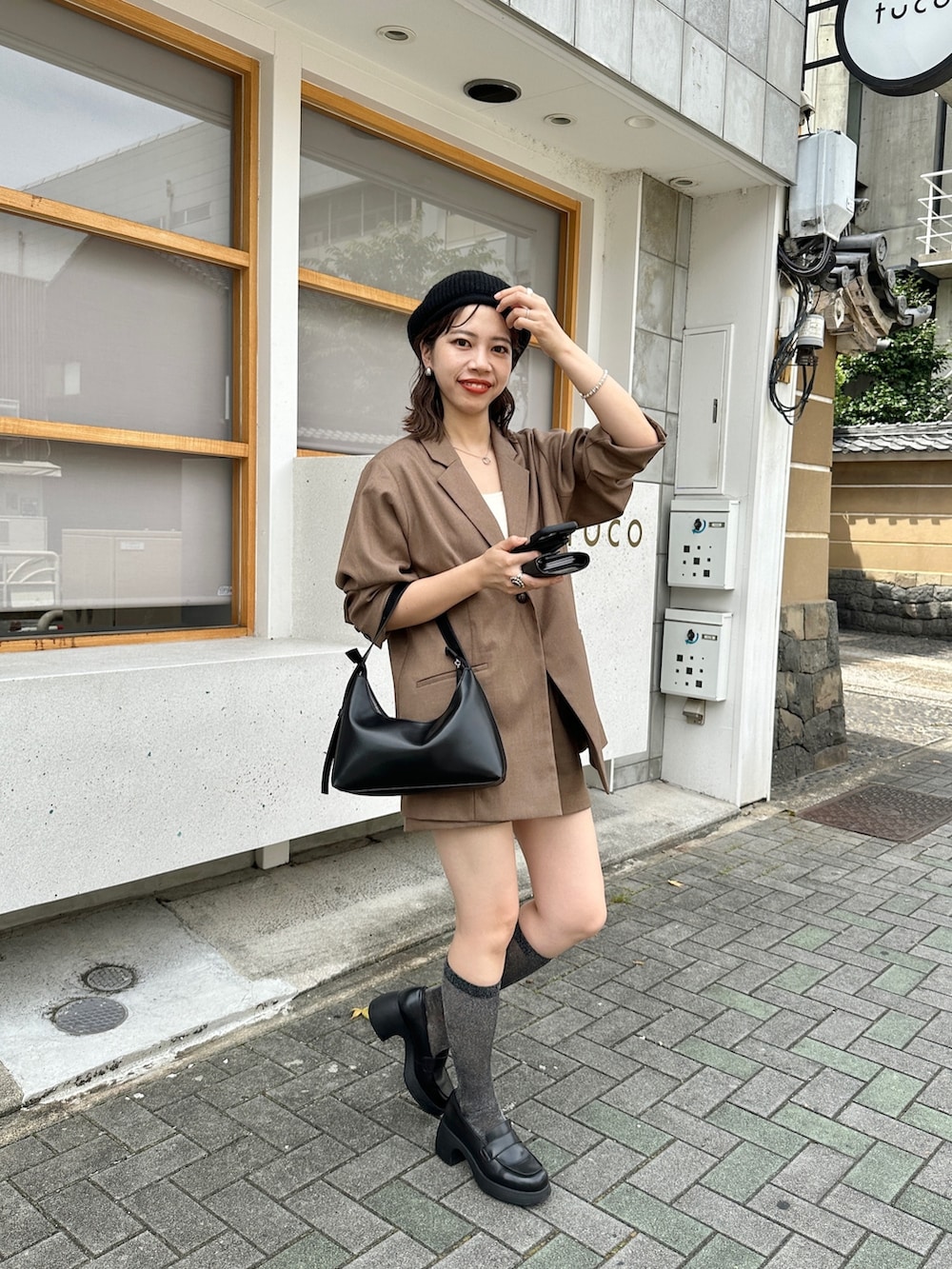 ブラウン系のパンツ、ブラウン系のテーラードジャケット、ブラック系のハンチング/ベレー帽を着用したレディースの夏コーディネートの2枚目の写真