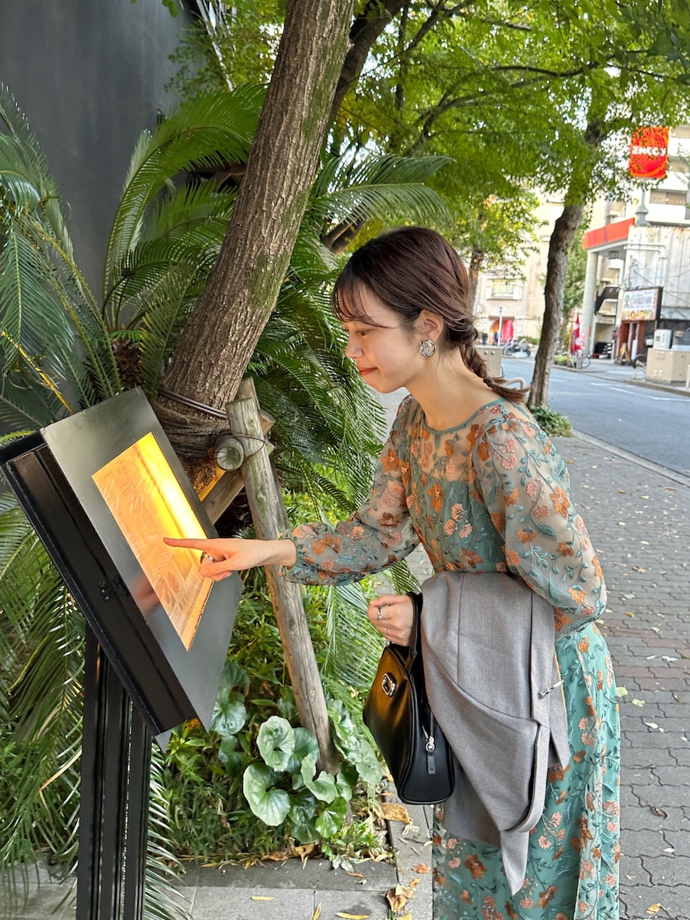 グリーン系のワンピース/ドレス、ブラック系のボストンバッグ、ブラック系のパンプスを着用したレディースの冬コーディネートの5枚目の写真