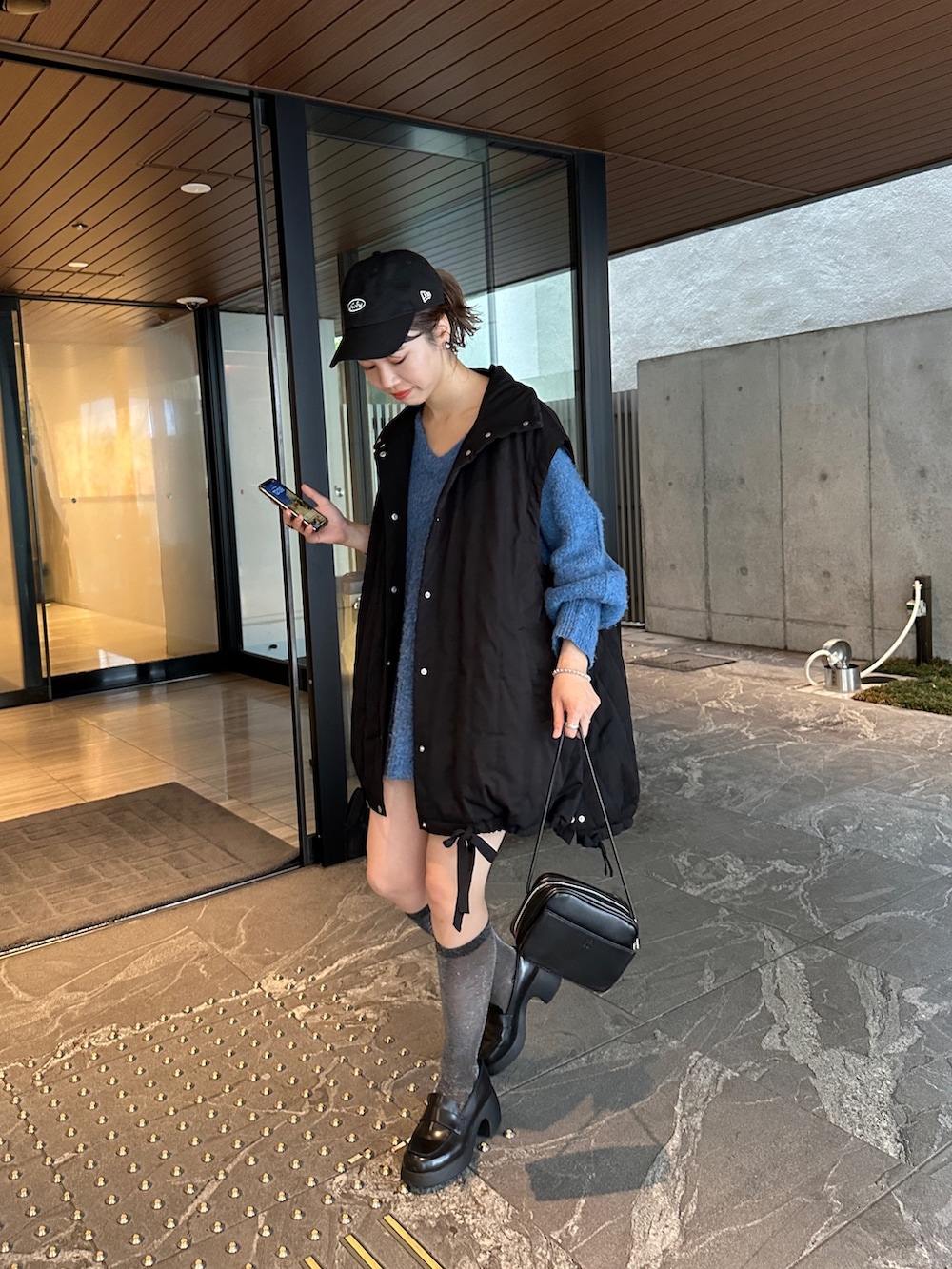 ブルー系のニット/セーター、ブラック系のジャケット/アウターを着用したレディースの夏コーディネートの6枚目の写真