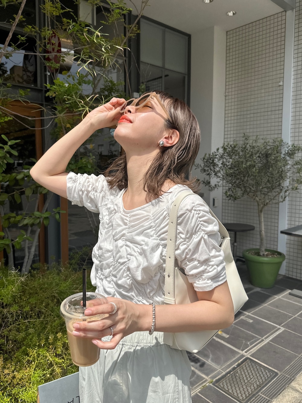 グリーン系のカーゴパンツ、ホワイト系のTシャツ/カットソー、ブラック系のサンダルを着用したレディースの春コーディネートの5枚目の写真