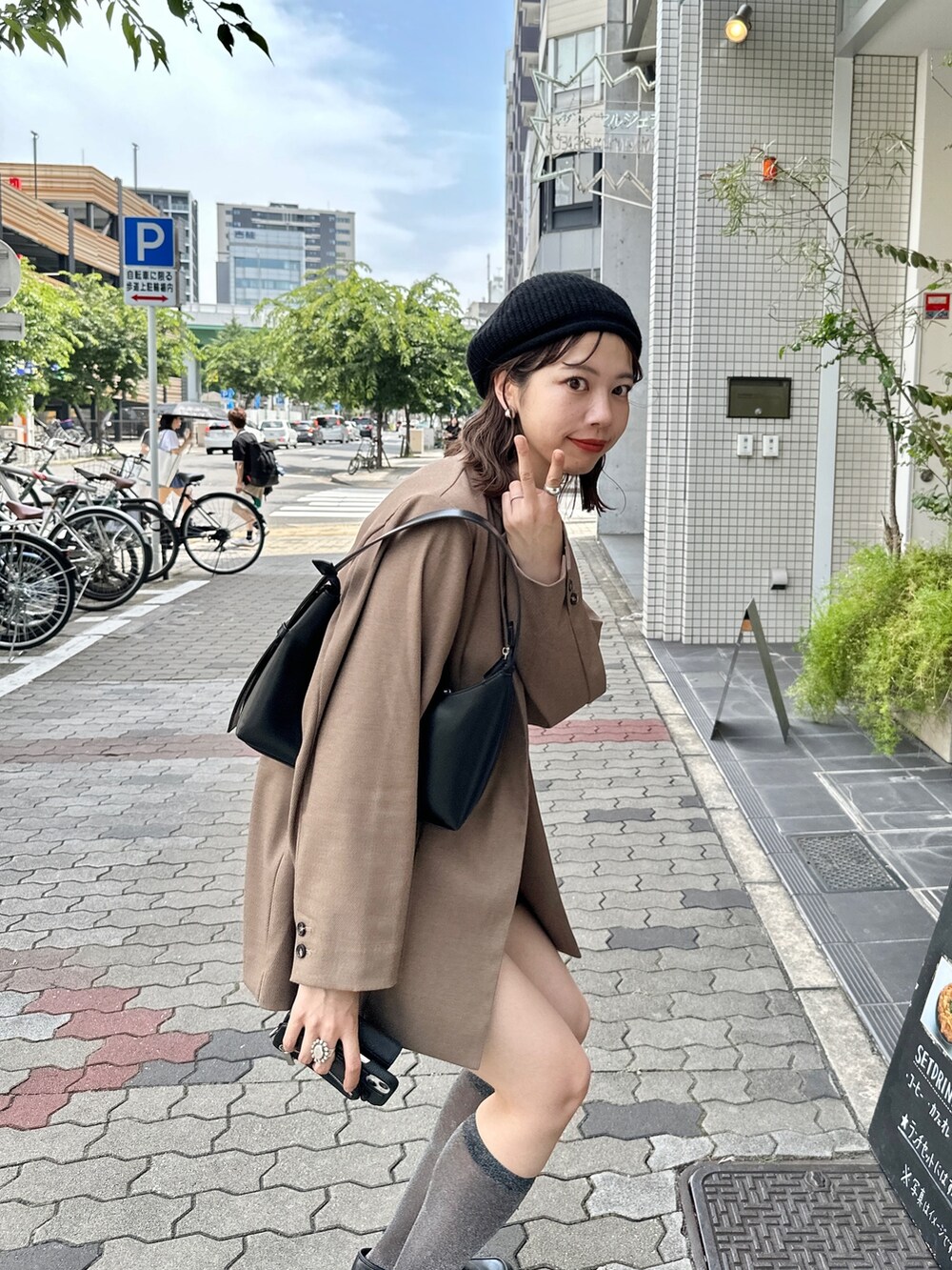 ブラウン系のパンツ、ブラウン系のテーラードジャケット、ブラック系のハンチング/ベレー帽を着用したレディースの夏コーディネートの3枚目の写真