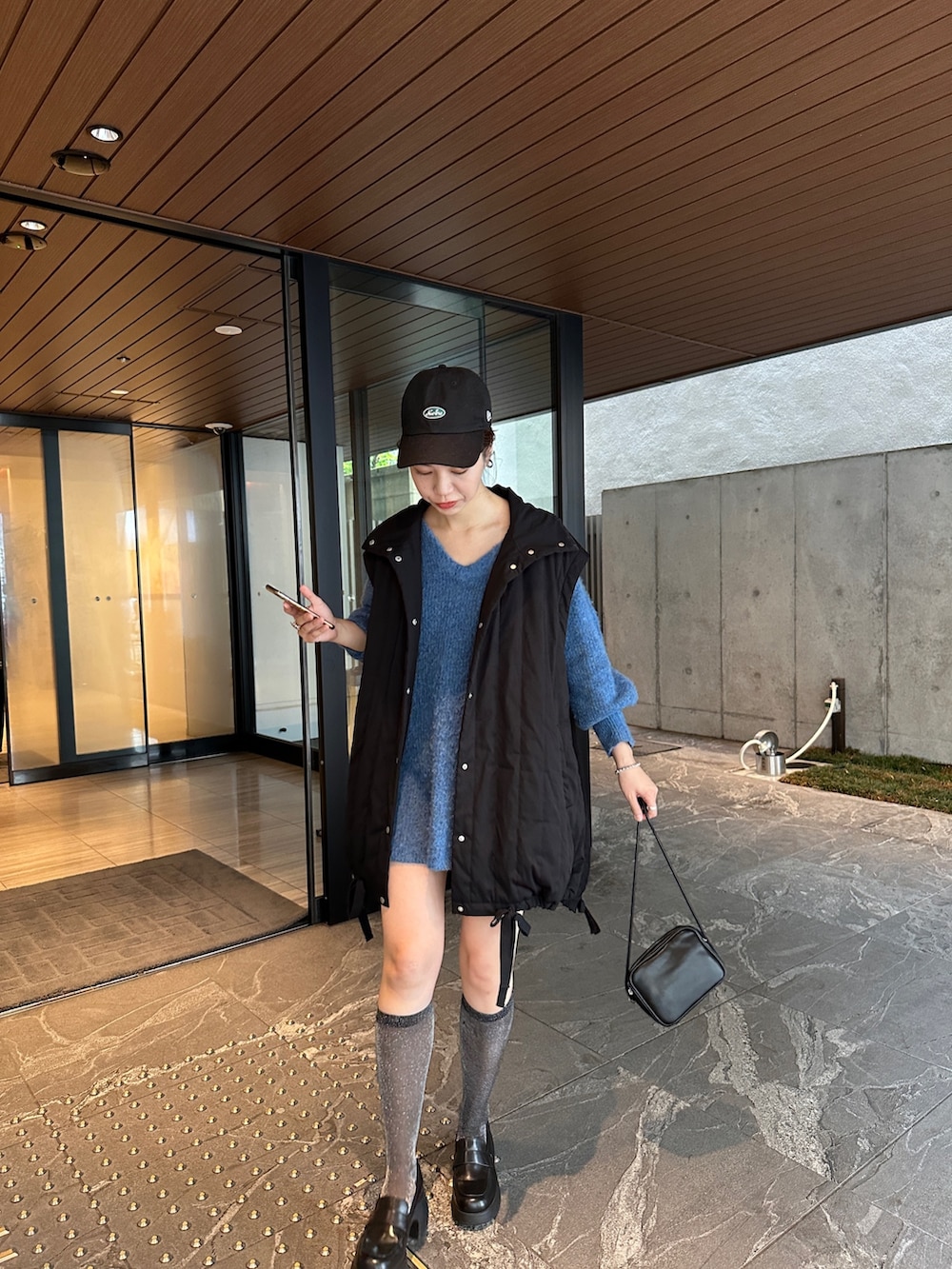 ブルー系のニット/セーター、ブラック系のジャケット/アウターを着用したレディースの夏コーディネートの3枚目の写真