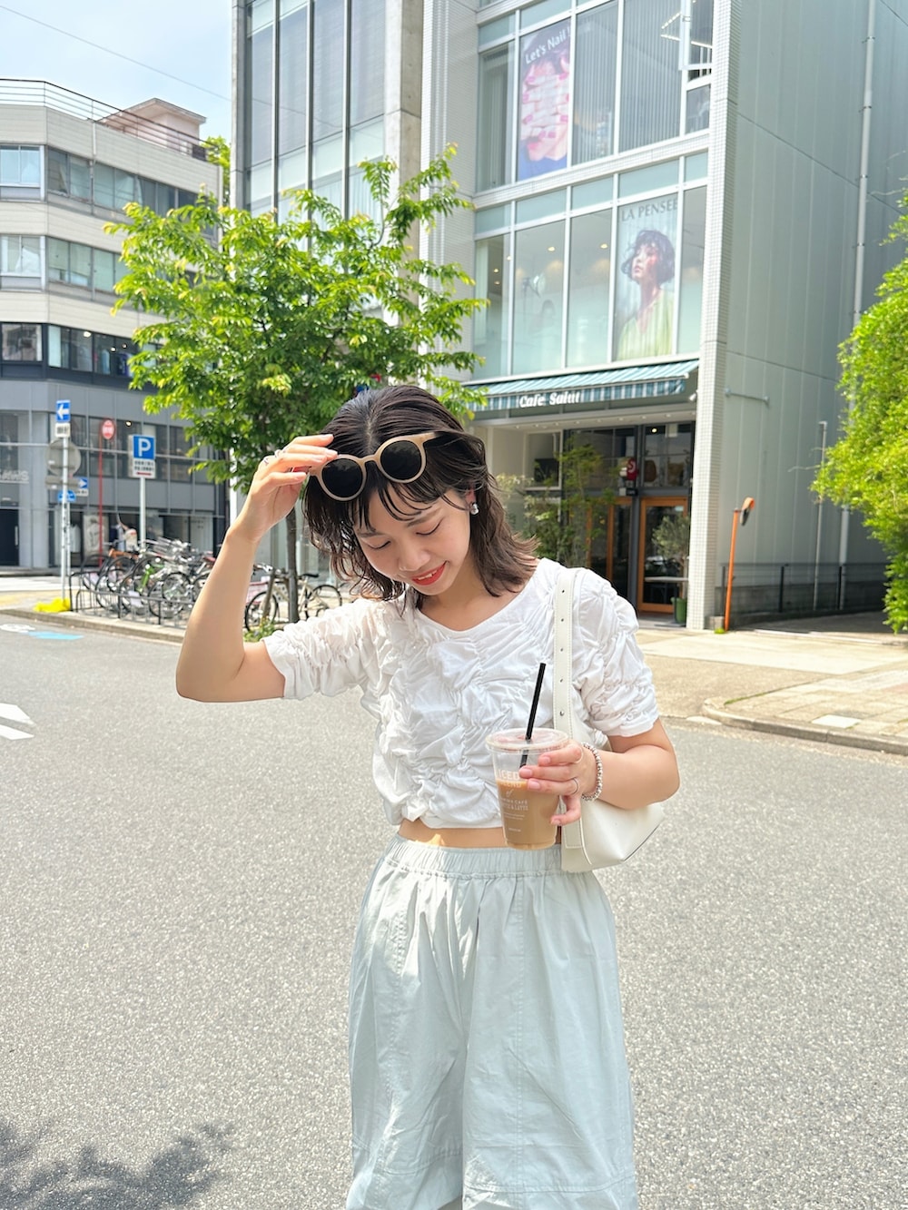 グリーン系のカーゴパンツ、ホワイト系のTシャツ/カットソー、ブラック系のサンダルを着用したレディースの春コーディネートの4枚目の写真