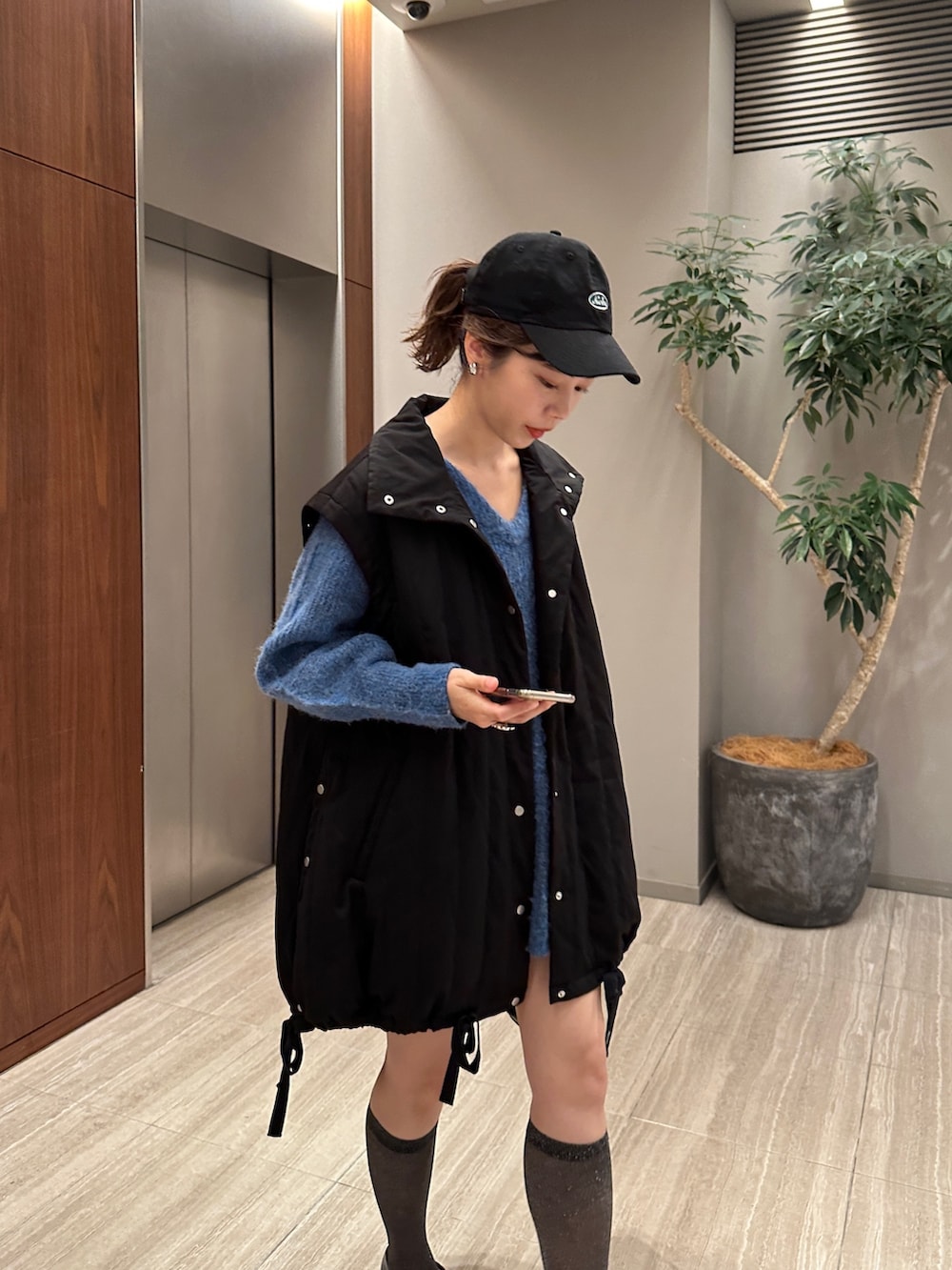 ブルー系のニット/セーター、ブラック系のジャケット/アウターを着用したレディースの夏コーディネートの4枚目の写真