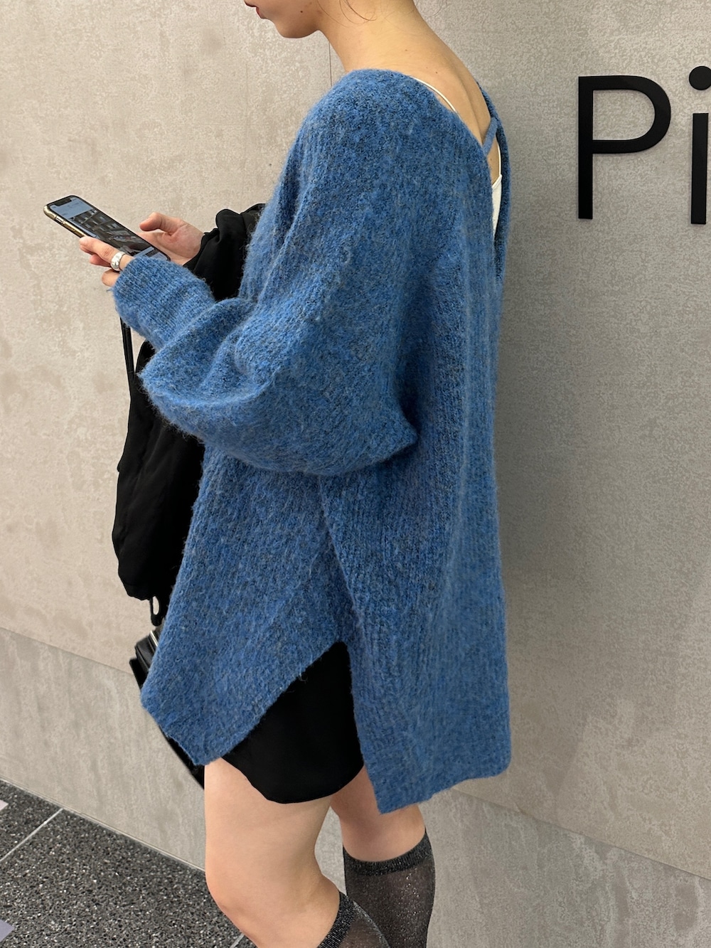 ブルー系のニット/セーター、ブラック系のジャケット/アウターを着用したレディースの夏コーディネートの7枚目の写真