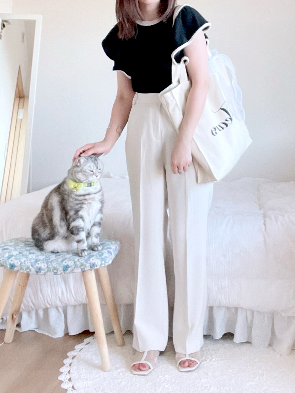 ブラック系のトップス、ホワイト系のその他パンツ、ホワイト系のトートバッグを着用したレディースの夏コーディネートの2枚目の写真