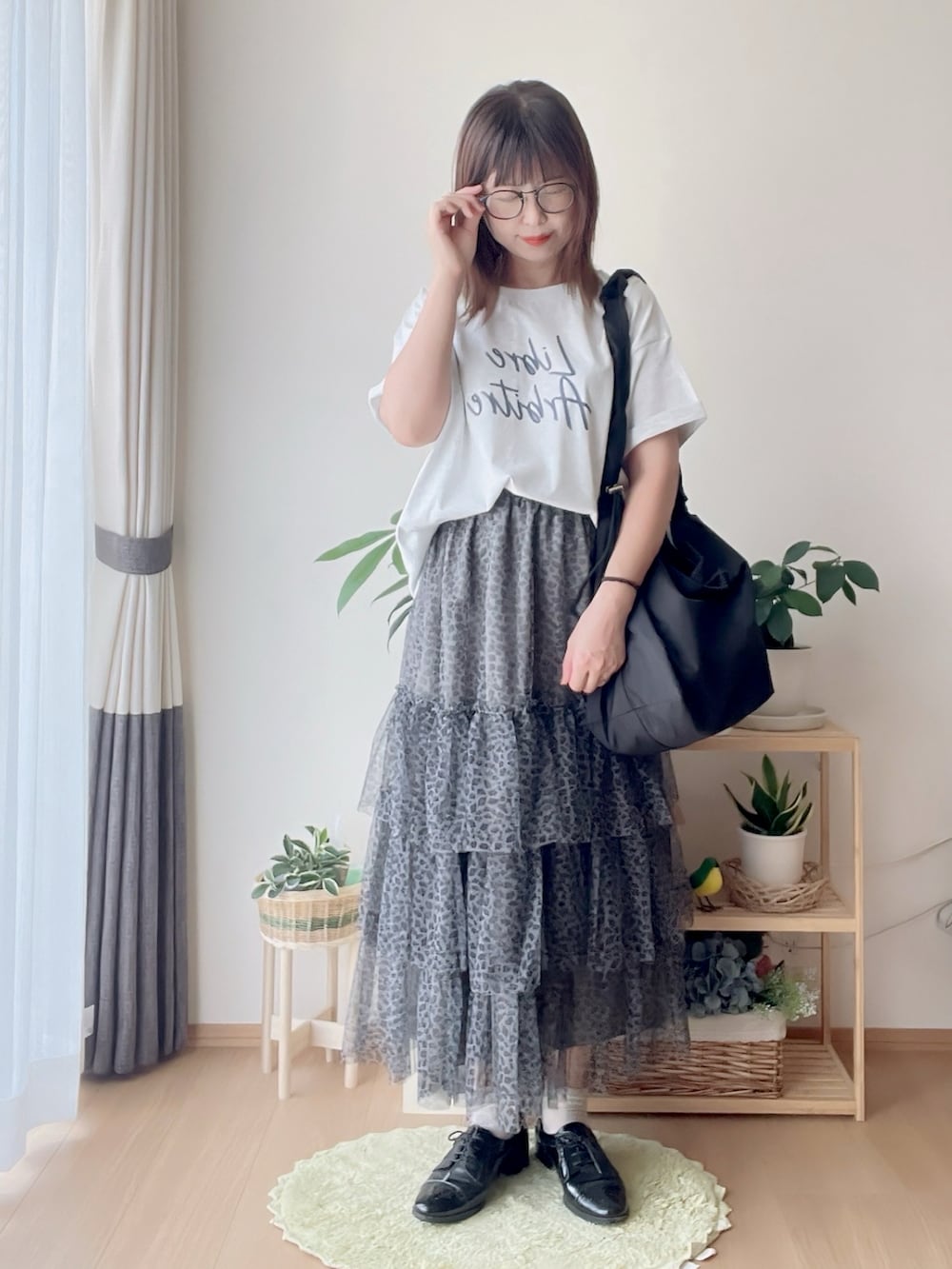 ベージュ系のTシャツ/カットソー、グレー系のスカート、ブラック系のショルダーバッグを着用したレディースの夏コーディネートの2枚目の写真