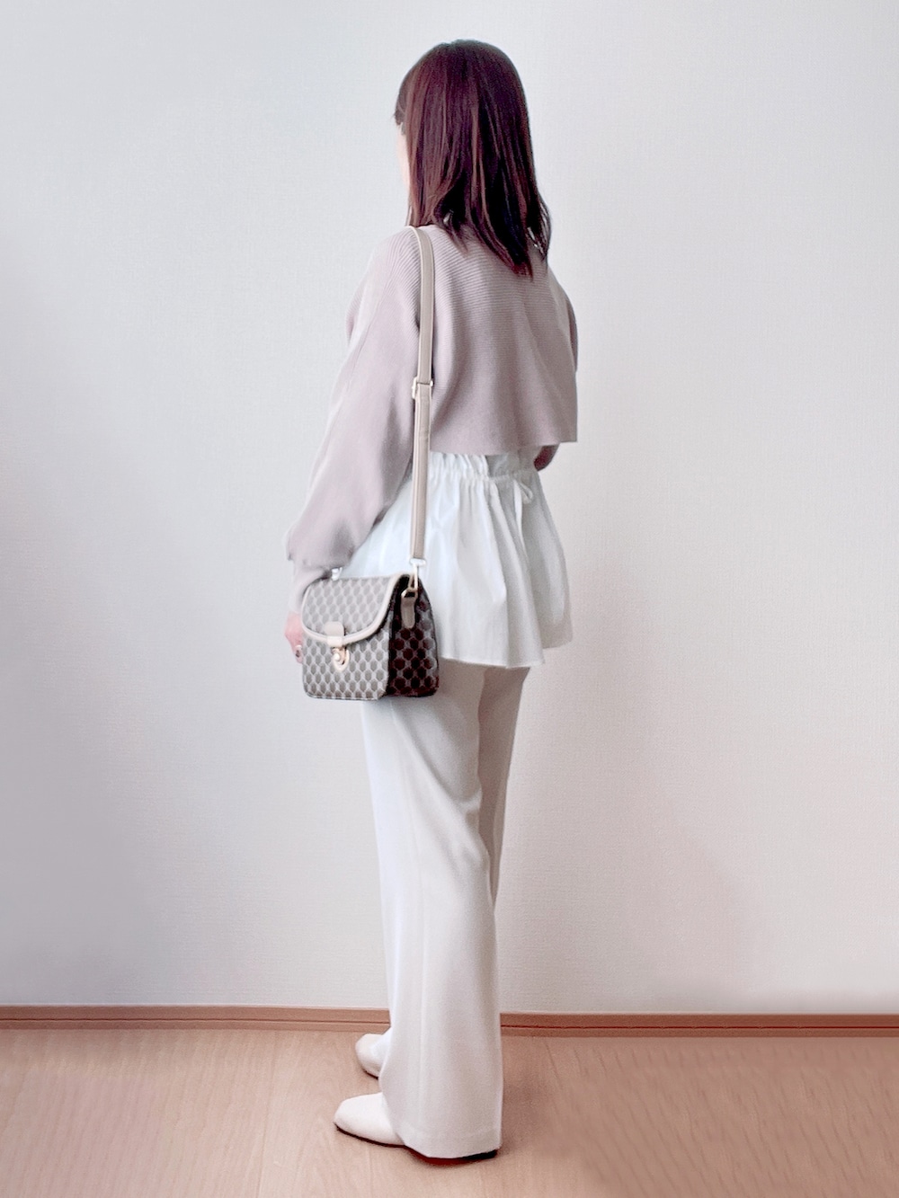 ブラウン系のニット/セーター、ホワイト系のその他パンツ、ブラウン系のショルダーバッグを着用したレディースの冬コーディネートの2枚目の写真