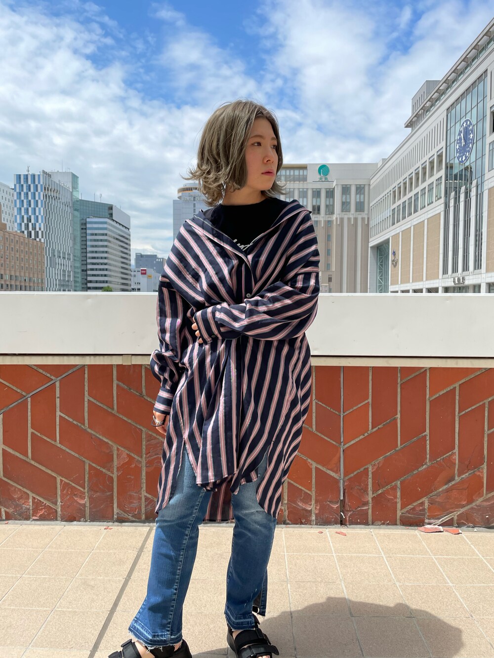 グレー系のトップス、ブラック系のTシャツ/カットソー、ブルー系のデニムパンツを着用したレディースの夏コーディネートの2枚目の写真