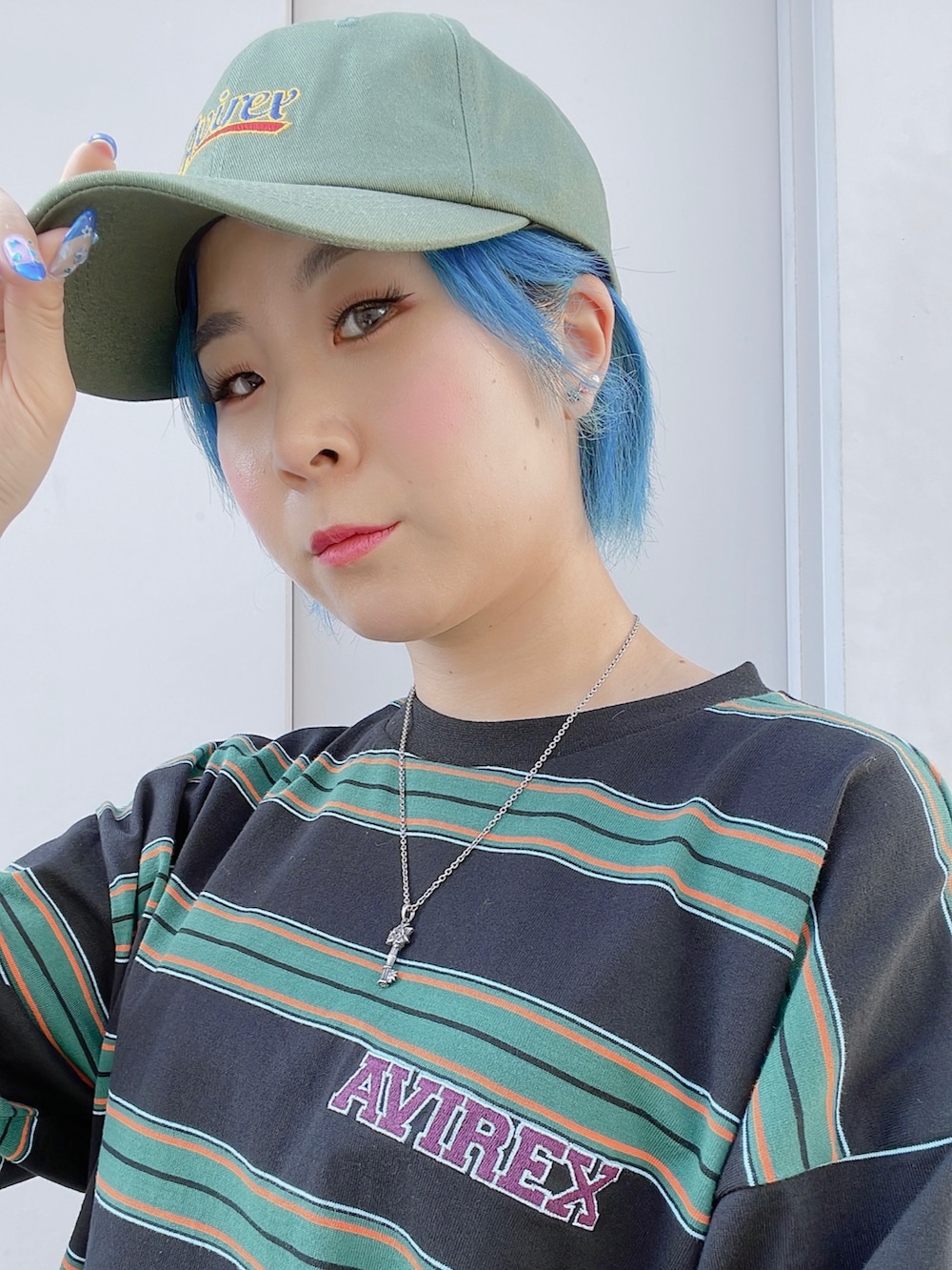 グリーン系のTシャツ/カットソー、ホワイト系のカーゴパンツ、グリーン系のキャップを着用したレディースの夏コーディネートの3枚目の写真