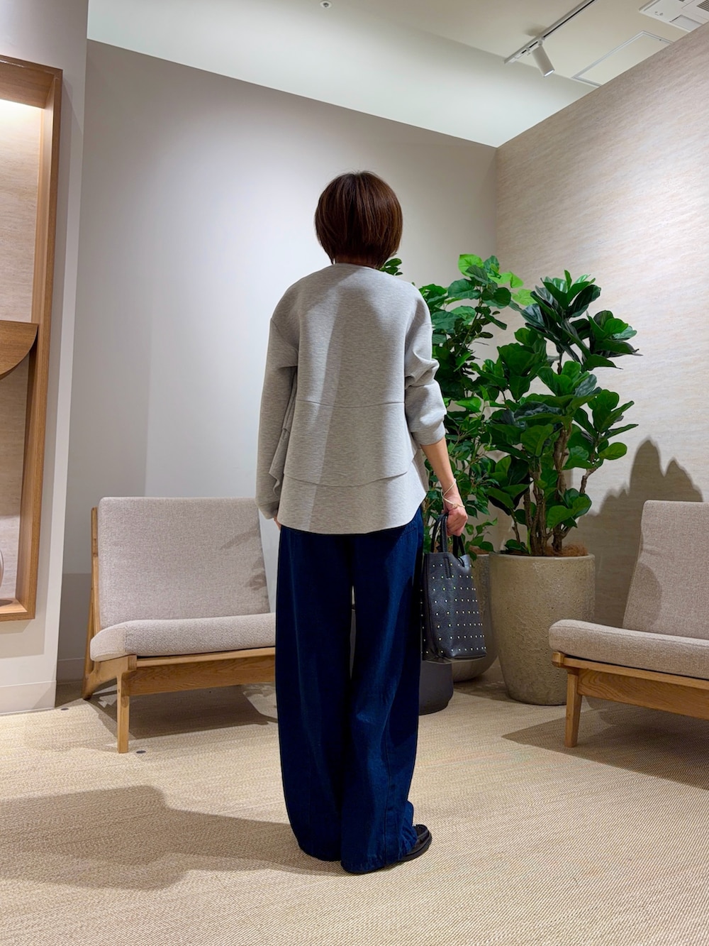 グレー系のTシャツ/カットソー、ブルー系のデニムパンツを着用したレディースの秋コーディネートの2枚目の写真