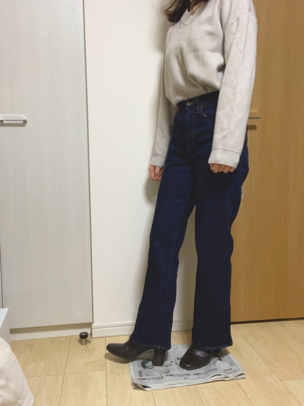 ブラウン系のブーツ、ブルー系のデニムパンツ、ホワイト系のニット/セーターを着用したレディースの冬コーディネートの2枚目の写真