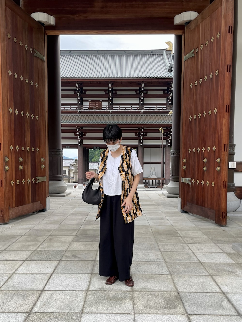 ホワイト系のトップス、その他のベスト、ブラック系のハンドバッグを着用したレディースの夏コーディネートの2枚目の写真