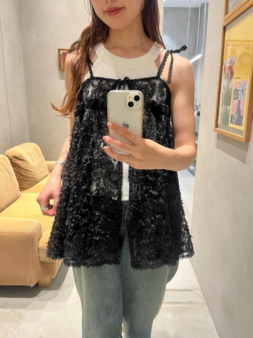 ブラック系のチュニック、ホワイト系のキャミソール、ブルー系のデニムパンツを着用したレディースの夏コーディネートの3枚目の写真