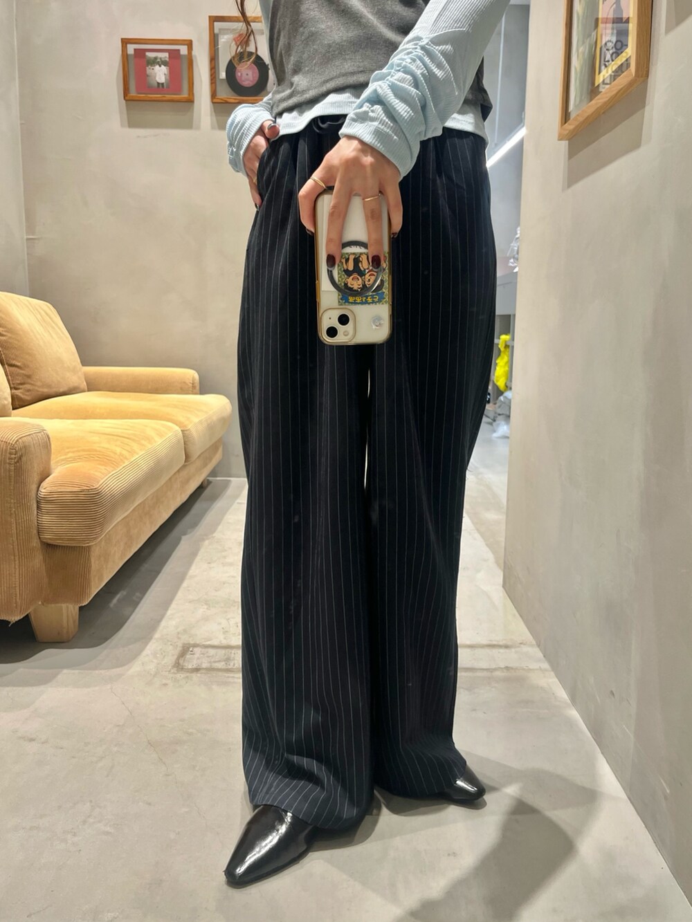 グレー系のTシャツ/カットソー、ブラック系のパンプス、ブルー系のスラックスを着用したレディースの秋コーディネートの3枚目の写真