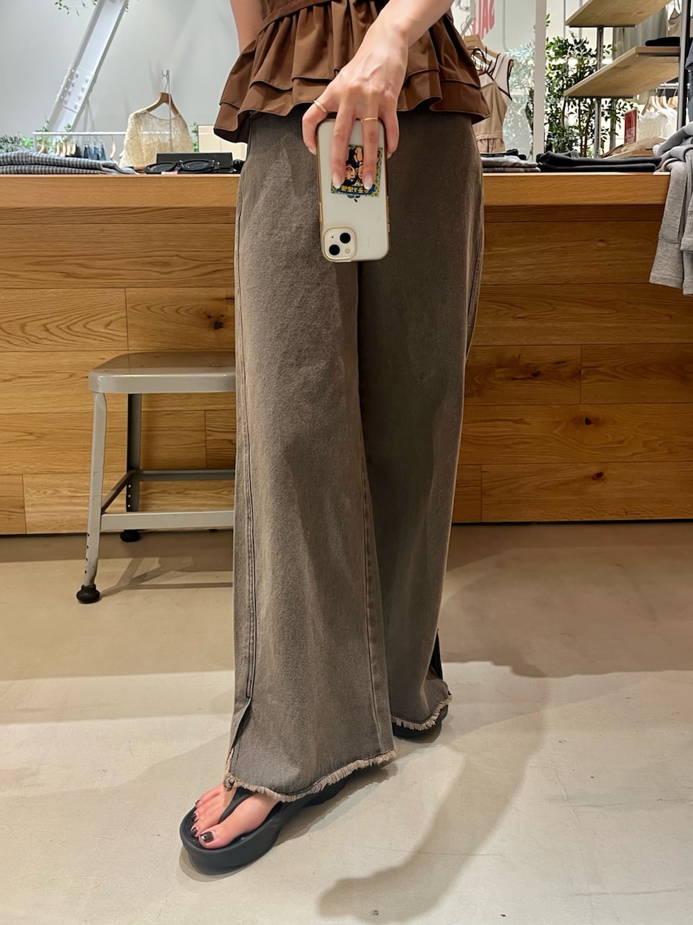 ブラウン系のキャミソール、ブルー系のタンクトップ、グレー系のデニムパンツを着用したレディースの夏コーディネートの3枚目の写真