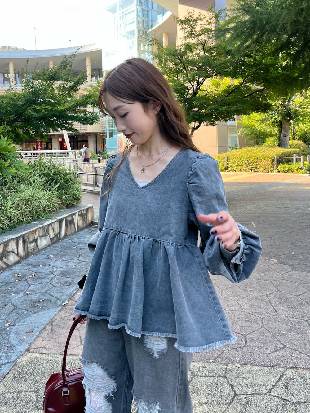 グレー系のシャツ/ブラウス、ブラック系のデニムパンツ、ブラック系のパンプスを着用したレディースの秋コーディネートの2枚目の写真