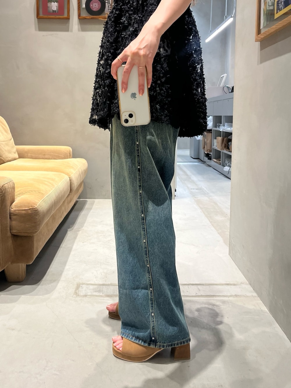 ブラック系のチュニック、ホワイト系のキャミソール、ブルー系のデニムパンツを着用したレディースの夏コーディネートの4枚目の写真