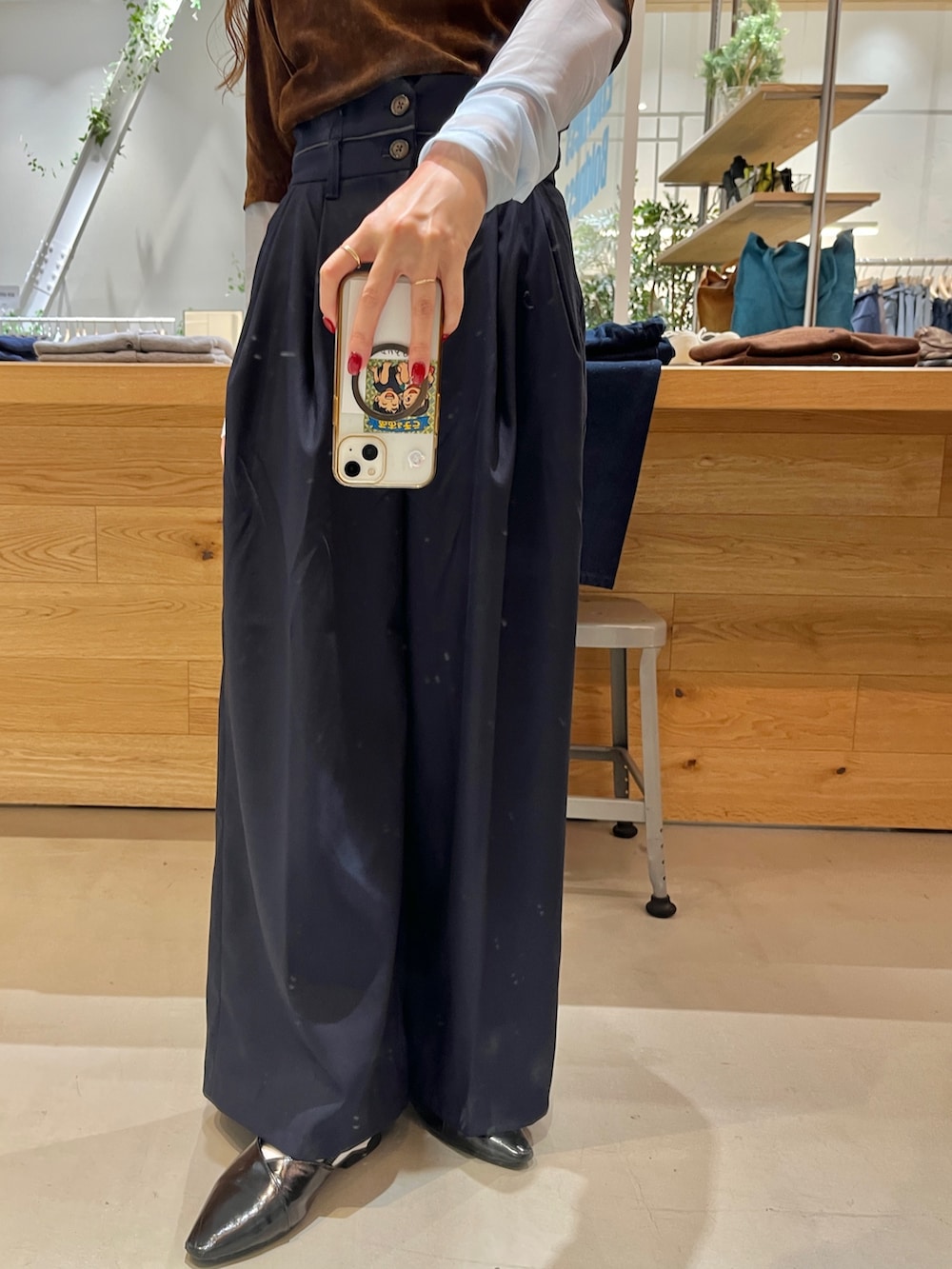 ブルー系のスラックス、ブラウン系のTシャツ/カットソー、ブラック系のパンプスを着用したレディースの秋コーディネートの3枚目の写真