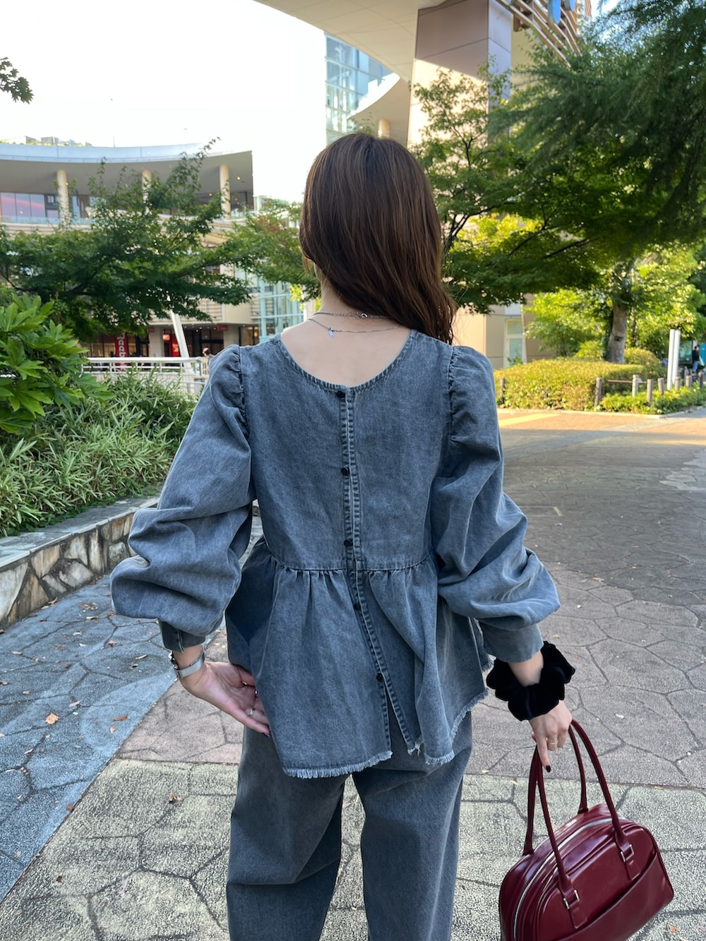 グレー系のシャツ/ブラウス、ブラック系のデニムパンツ、ブラック系のパンプスを着用したレディースの秋コーディネートの3枚目の写真