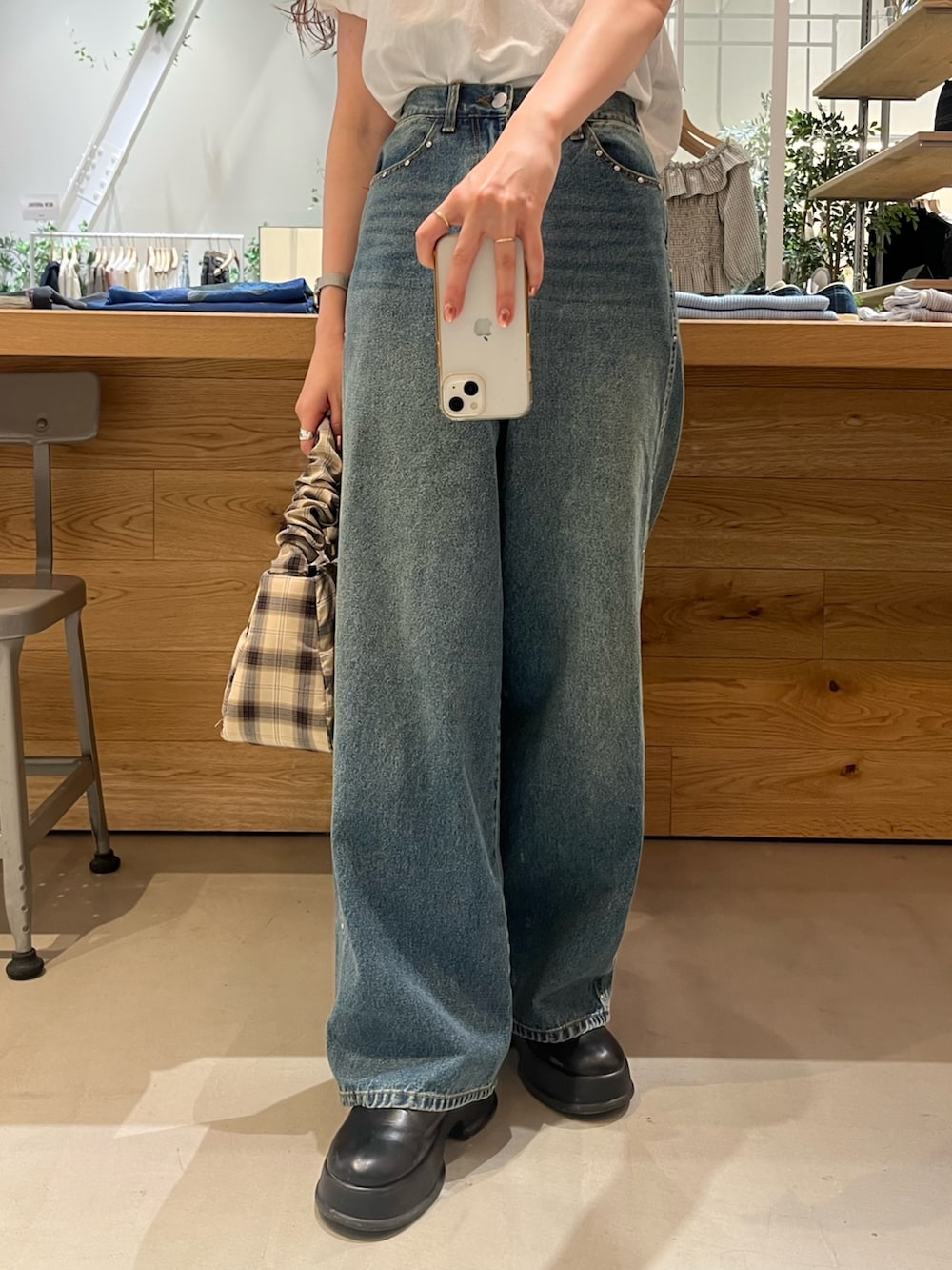 ブルー系のデニムパンツ、ホワイト系のシャツ/ブラウス、ベージュ系のトートバッグを着用したレディースの夏コーディネートの2枚目の写真