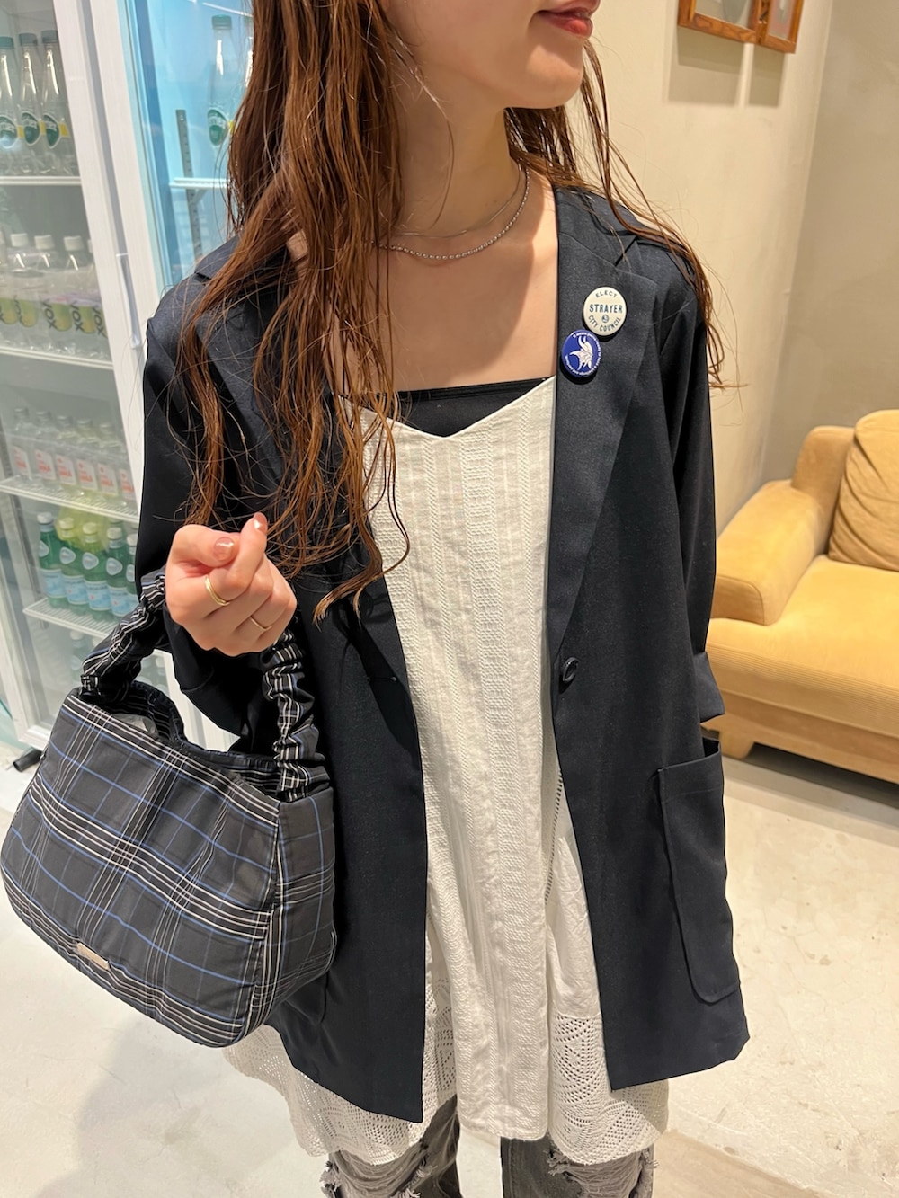 ブラック系のトートバッグ、ブラック系のデニムパンツ、ホワイト系のワンピースを着用したレディースの夏コーディネートの2枚目の写真
