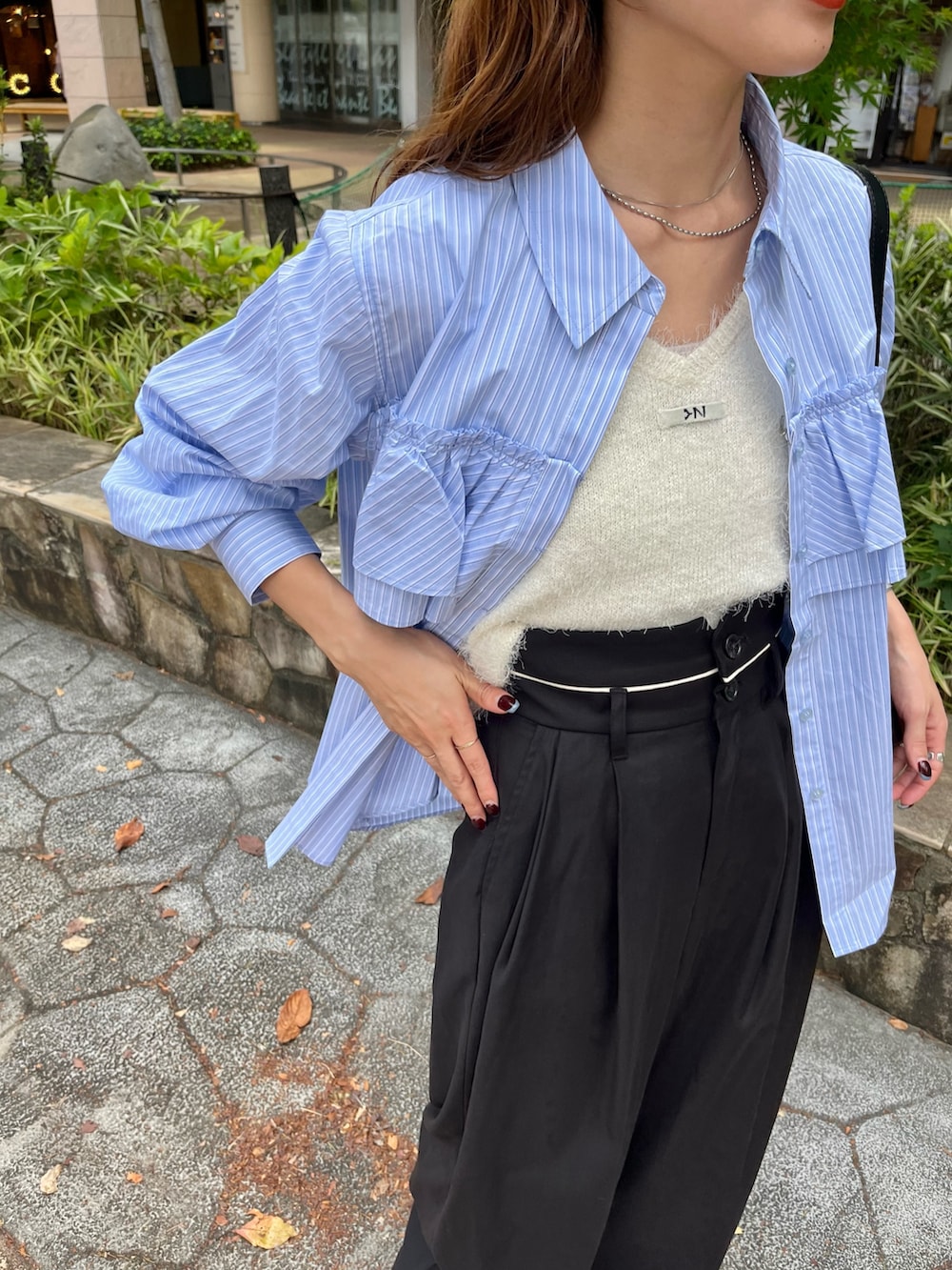 ブラック系のトートバッグ、ブルー系のスラックス、ブルー系のシャツ/ブラウスを着用したレディースの秋コーディネートの2枚目の写真