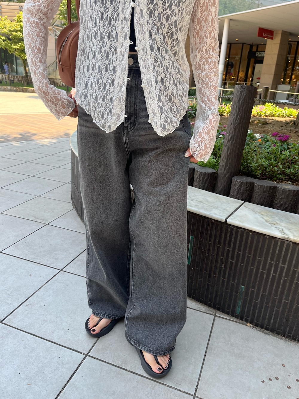 ホワイト系のTシャツ/カットソー、ブラウン系のボストンバッグ、ブラック系のデニムパンツを着用したレディースの夏コーディネートの3枚目の写真