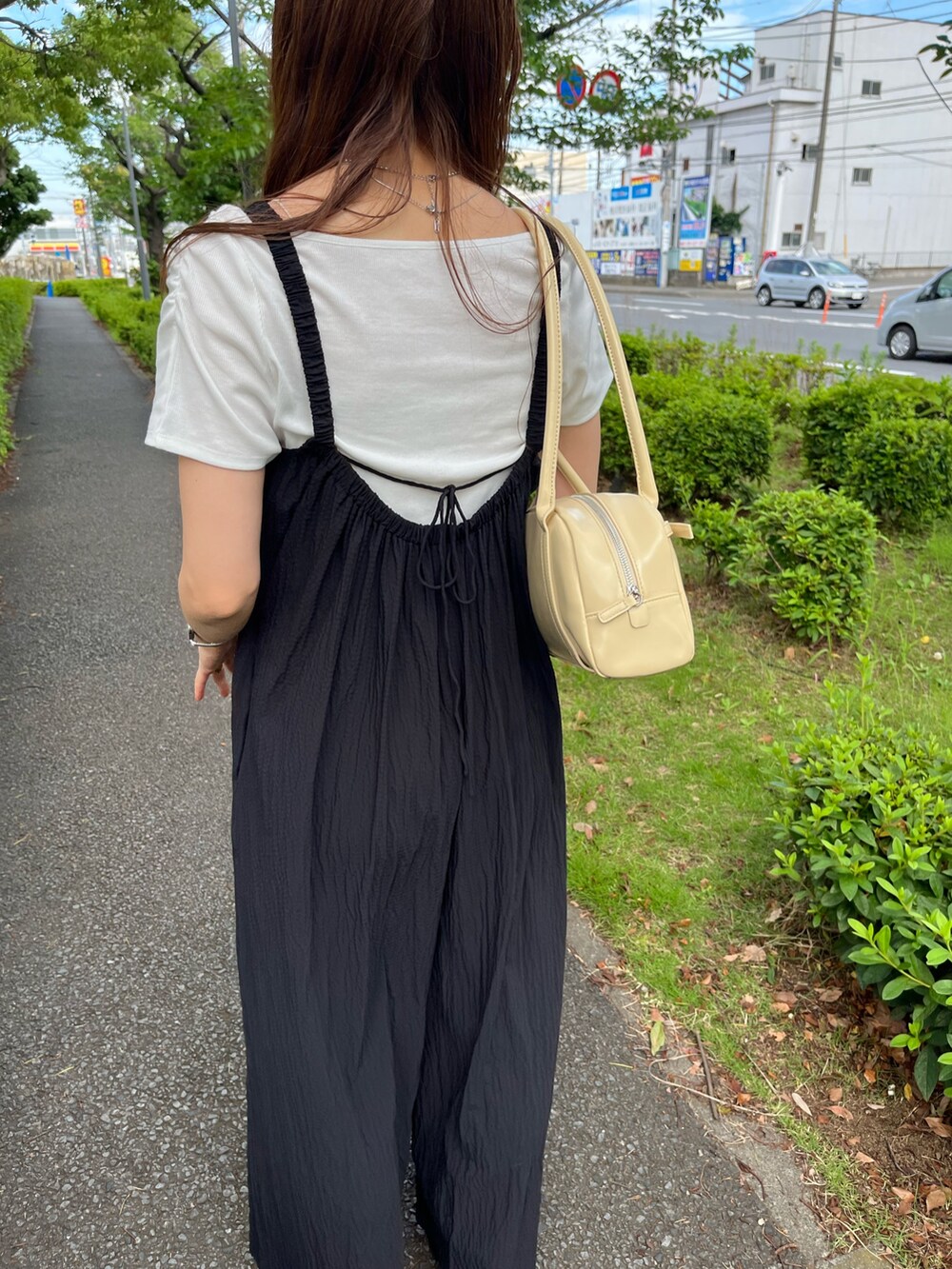 ブラック系のサロペット/オーバーオール、イエロー系のボストンバッグを着用したレディースの夏コーディネートの4枚目の写真