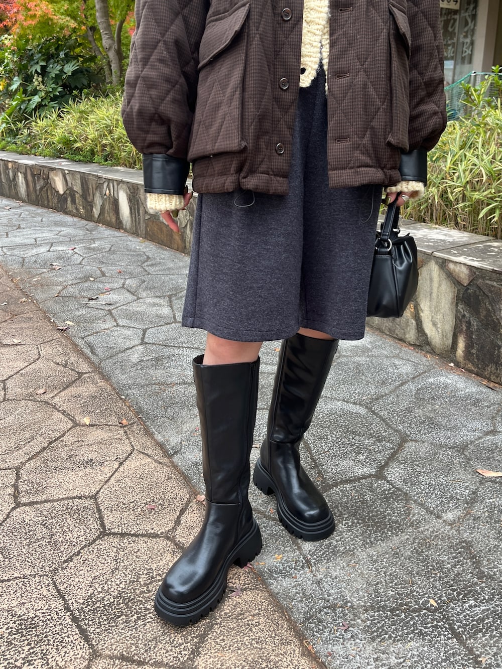 ブラウン系のその他アウター、ブラック系のブーツ、ブラック系のショルダーバッグを着用したレディースの冬コーディネートの3枚目の写真