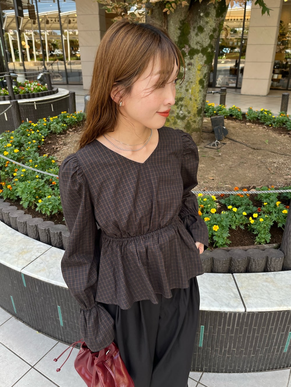 ブラウン系のシャツ/ブラウス、レッド系のショルダーバッグ、ブラック系のスラックスを着用したレディースの秋コーディネートの2枚目の写真