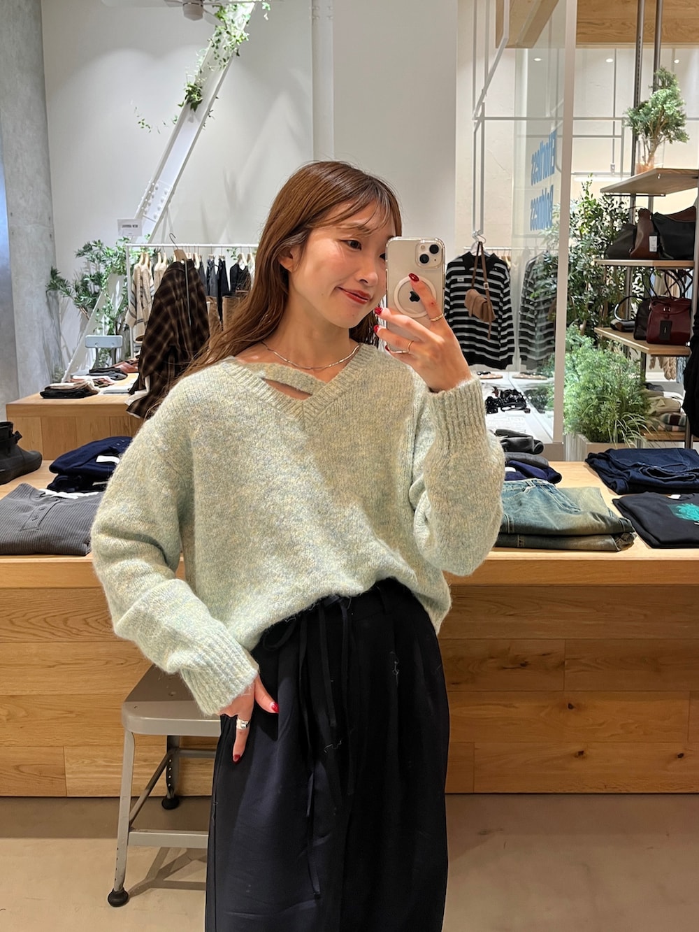 グリーン系のニット/セーター、ブルー系のスラックス、シルバー系のネックレスを着用したレディースの秋コーディネートの3枚目の写真