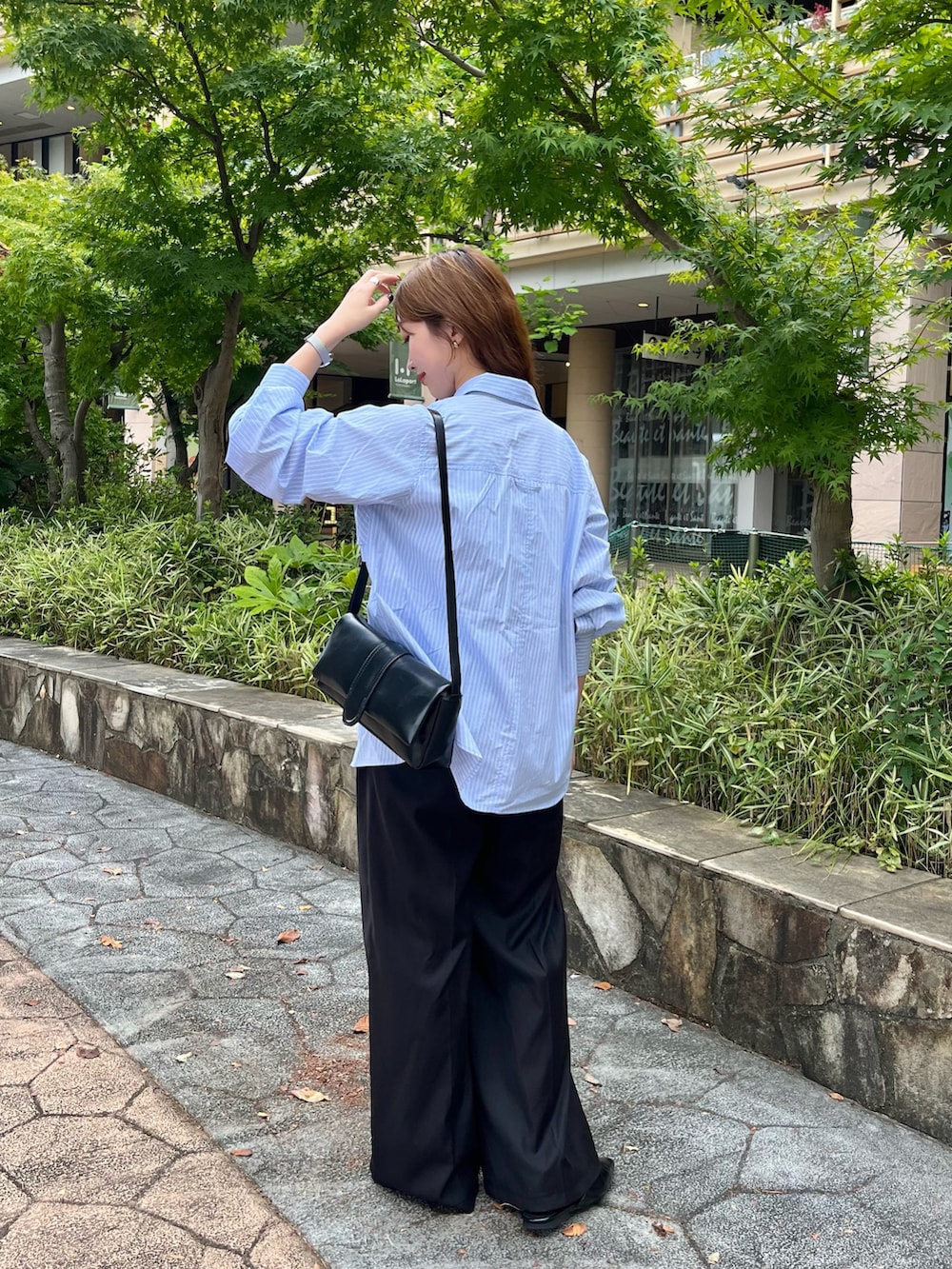 ブラック系のトートバッグ、ブルー系のスラックス、ブルー系のシャツ/ブラウスを着用したレディースの秋コーディネートの4枚目の写真