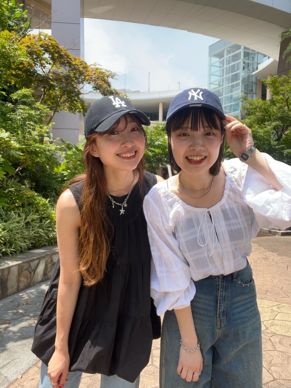 ブラック系のチュニック、ブルー系のデニムパンツ、ブルー系のデニムパンツを着用したレディースの夏コーディネートの2枚目の写真