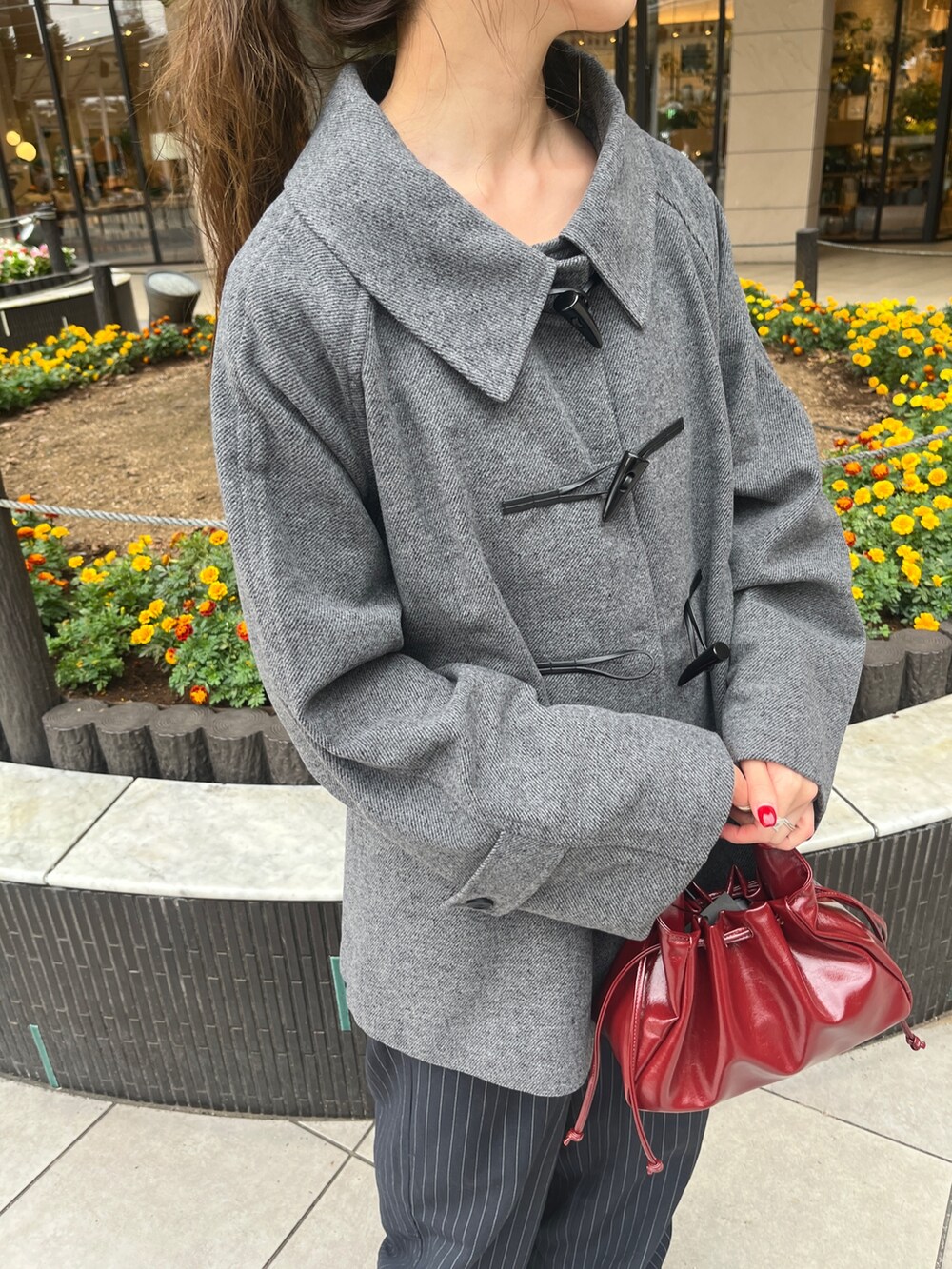 グレー系のその他アウター、レッド系のショルダーバッグ、ブルー系のスラックスを着用したレディースの秋コーディネートの4枚目の写真