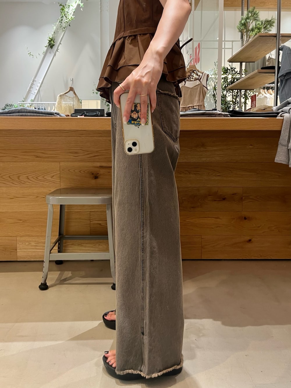 ブラウン系のキャミソール、ブルー系のタンクトップ、グレー系のデニムパンツを着用したレディースの夏コーディネートの4枚目の写真