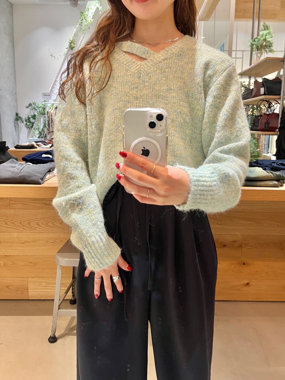 グリーン系のニット/セーター、ブルー系のスラックス、シルバー系のネックレスを着用したレディースの秋コーディネートの2枚目の写真