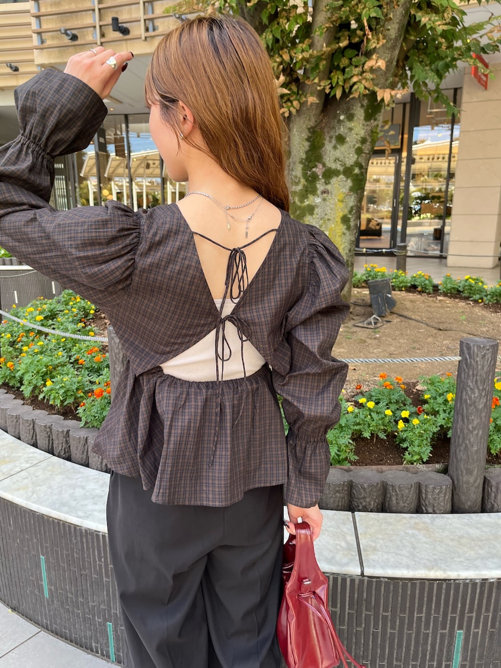 ブラウン系のシャツ/ブラウス、レッド系のショルダーバッグ、ブラック系のスラックスを着用したレディースの秋コーディネートの3枚目の写真