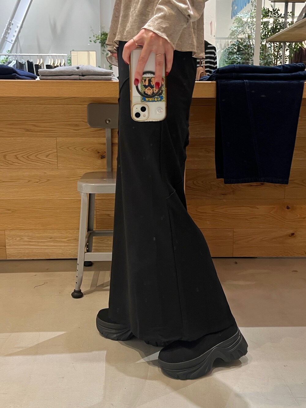 ベージュ系のTシャツ/カットソー、ブラック系のボストンバッグ、ブラック系のブーツを着用したレディースの秋コーディネートの3枚目の写真