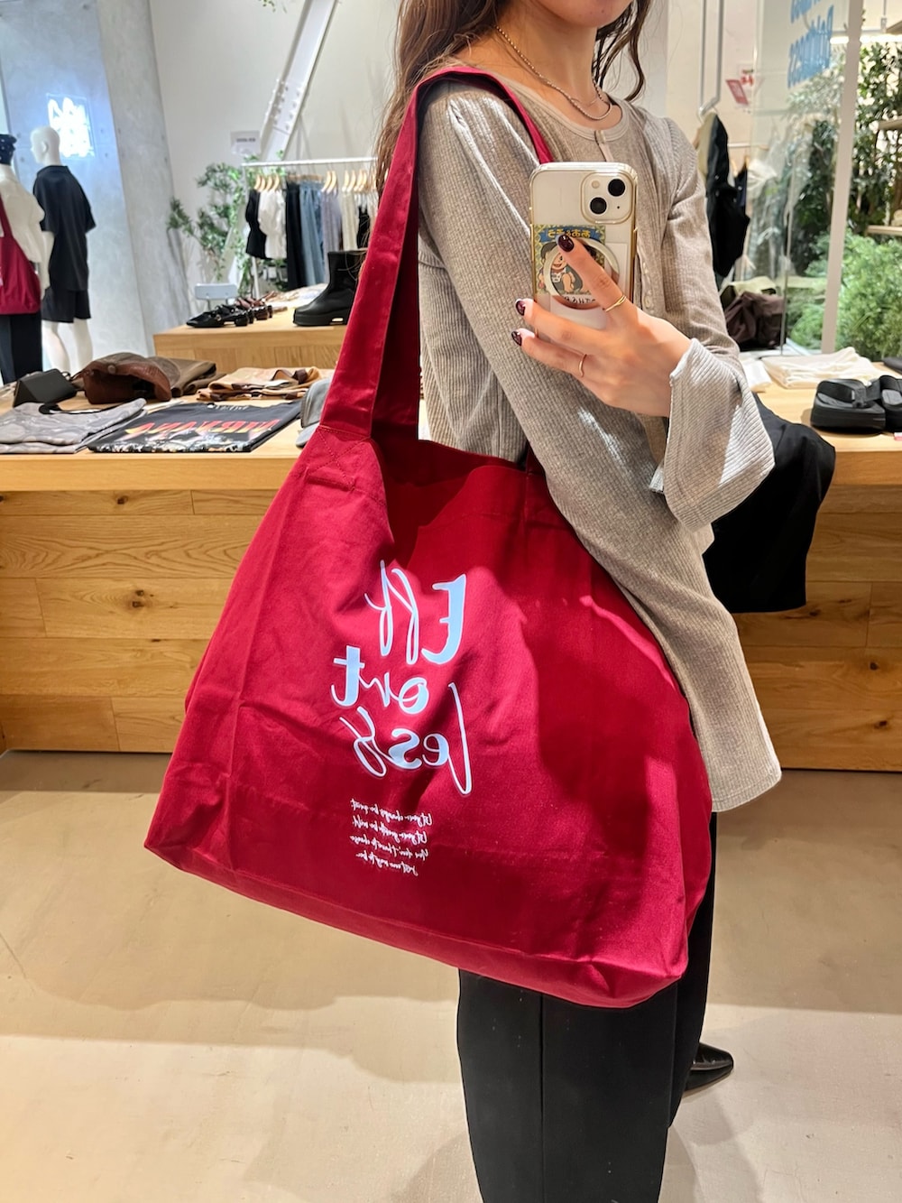 レッド系のトートバッグ、グレー系のTシャツ/カットソー、ブラック系のその他パンツを着用したレディースの秋コーディネートの2枚目の写真