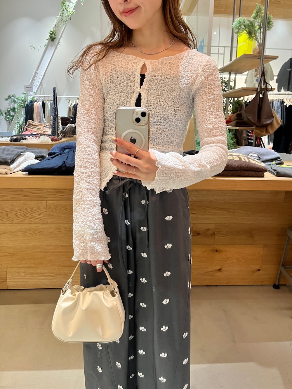 ホワイト系のショルダーバッグ、グレー系のその他パンツ、ホワイト系のカーディガン/ボレロを着用したレディースの冬コーディネートの2枚目の写真