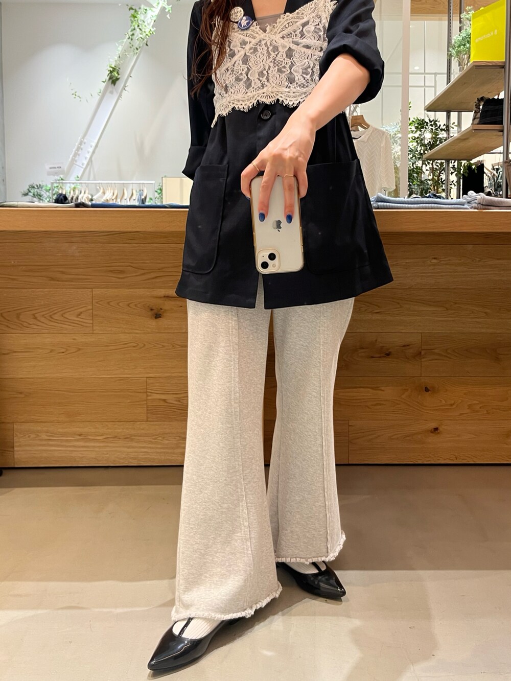 グレー系のその他パンツ、ブルー系のテーラードジャケット、ホワイト系のキャミソールを着用したレディースの春コーディネートの3枚目の写真