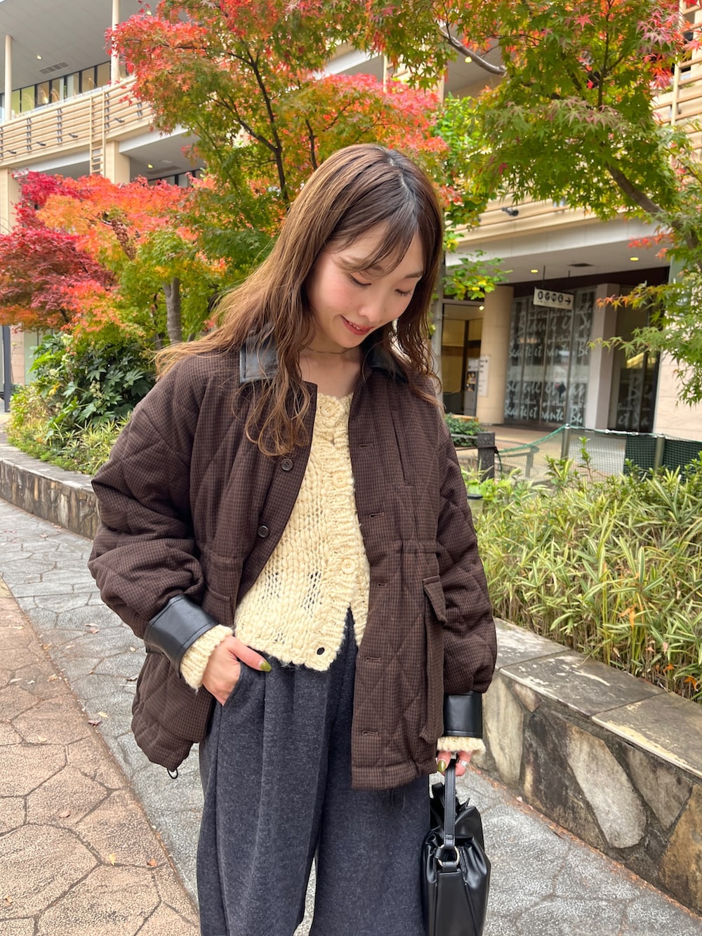 ブラウン系のその他アウター、ブラック系のブーツ、ブラック系のショルダーバッグを着用したレディースの冬コーディネートの2枚目の写真