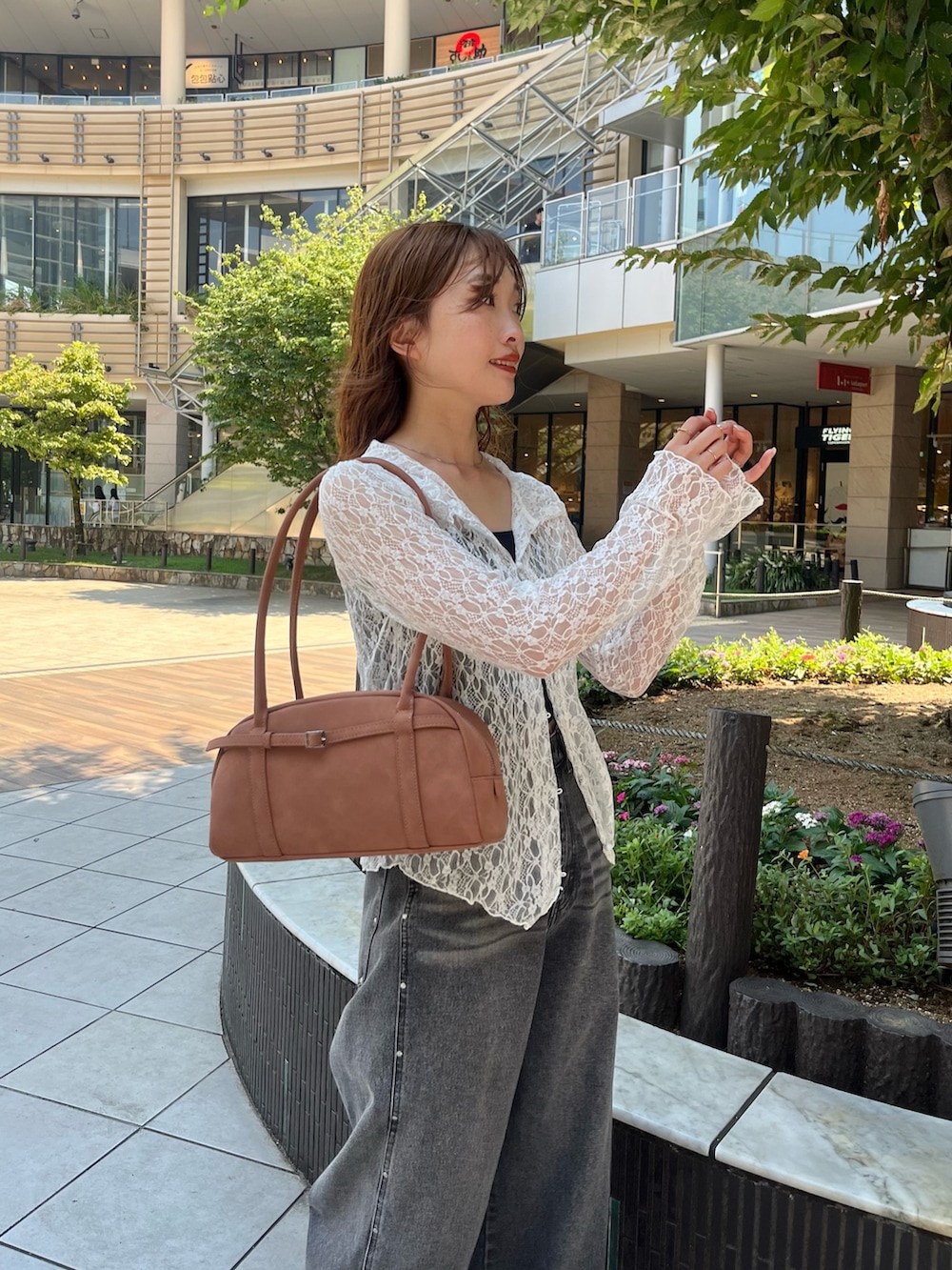 ホワイト系のTシャツ/カットソー、ブラウン系のボストンバッグ、ブラック系のデニムパンツを着用したレディースの夏コーディネートの2枚目の写真