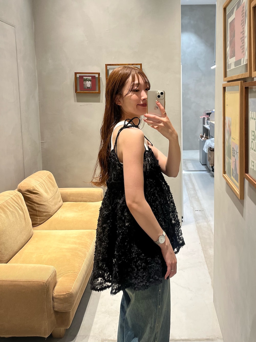 ブラック系のチュニック、ホワイト系のキャミソール、ブルー系のデニムパンツを着用したレディースの夏コーディネートの2枚目の写真