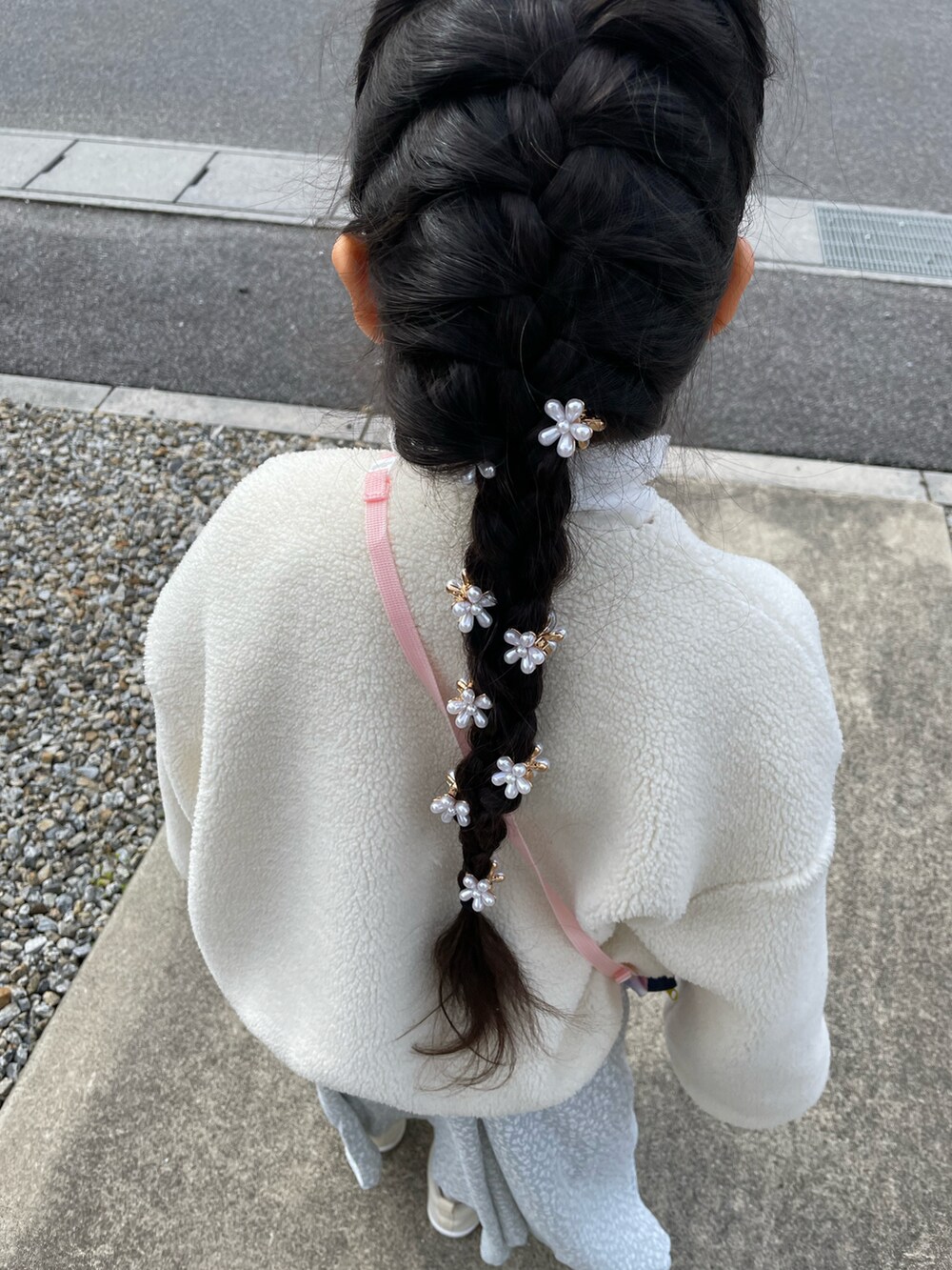 ホワイト系のブルゾン、ブルー系のワンピース、ホワイト系のスリッポンを着用したキッズの春コーディネートの2枚目の写真