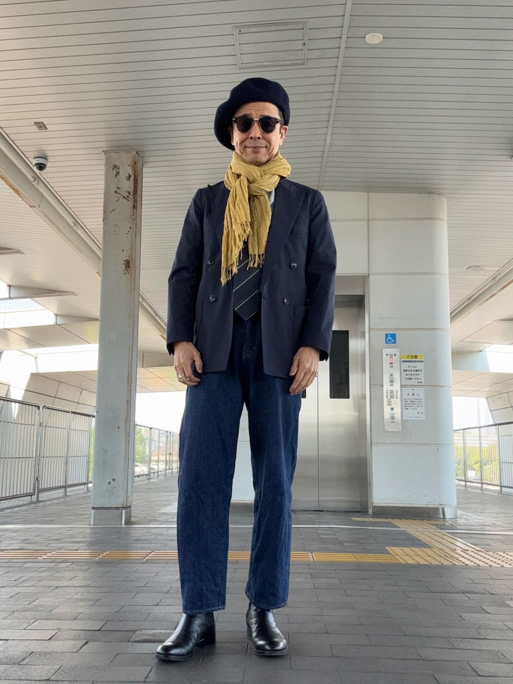 ブルー系のデニムパンツ、ブラック系のブーツ、ブルー系のテーラードジャケットを着用したメンズの春コーディネートの2枚目の写真